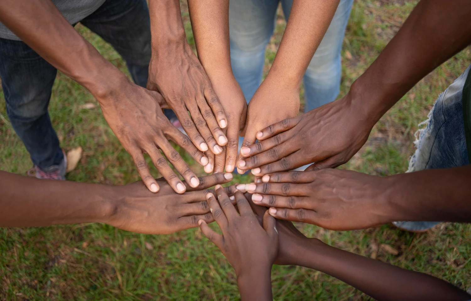A diverse group of individuals standing together, their hands joined in unity and solidarity.
