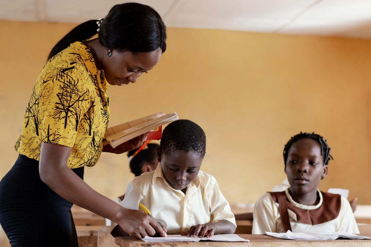 A teacher in a classroom, engaging with students, sharing knowledge, and fostering a learning environment.